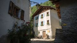 Il centro del borgo montano di Soglio, Canton Grigioni, Svizzera. Una tipica casetta illuminata dalla luce del sole.

