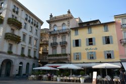 Il centro storico di Lugano (Svizzera) con palazzi antichi e attività commerciali.
