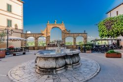 Il centro storico di Pitigliano con una fontana in pietra (Toscana) - © DiegoMariottini / Shutterstock.com