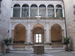 Il grazioso cortile interno di un palazzo medievale a Fermo, Marche. Al centro, il pozzo in pietra - © Claudio Giovanni Colombo / Shutterstock.com