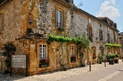 Il grazioso Palazzo Municipale di Monpazier, Francia: si tratta di un'antica costruzione in pietra abbellita da fiori colorati e piante rampicanti.

