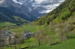 Il grazioso villaggio di Gavarnie nella valle del fiume Gave de Pau, Francia. Sullo sfondo, il celebre anfiteatro roccioso con cascate, ghiacciai e campi da sci.

