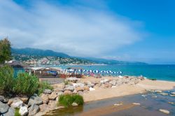 Il litorale di Le Lavandou, Francia, con ombrelloni colorati e ristoranti - © Juergen Wackenhut / Shutterstock.com