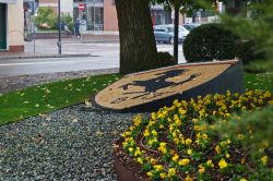 Il logo della Ferrari in un giardino del centro di Maranello - © Norbert Pencak / Shutterstock.com