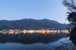 Il lungolago di Porto Ceresio, Lombardia, al crepuscolo in inverno. Siamo al confine con la Svizzera; sullo sfondo il monte Orsa.

