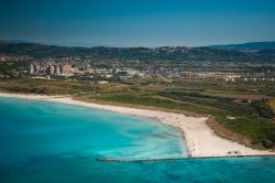 Il mare cristallino e le sabbie immacolate tipiche di Rosignano Solvay in Toscana. Sullo sfondo la fabbrica responsabile del magnifico "inquinamento" in stile caraibico