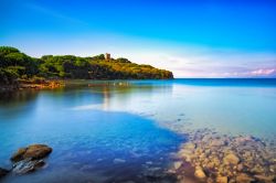 Il mare di Punta Ala con la spiaggia e la vecchia torre sullo sfondo, Toscana. Questa famosa località balneare adagiata sulle pendici settentrionali dell'omonimo promontorio è ...