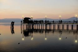 Il molo illuminato di sera al porto di Anguillara Sabazia, Lazio.

