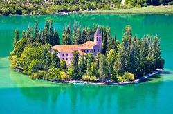 Il monastero dell'isola di Visovac nel Parco Nazionale di Krka, Dalmazia, Croazia. Quest'isolotto che sorge nelle acque del lago lungo il corso della Cherca ospita un convento francescano ...