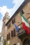 Il Palazzo Municipale del Comune di Buonconvento, Tocana, con le bandiere al balcone.
