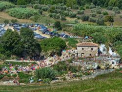 Il parcheggio delle Terme libere di Saturnia in Toscana, con le Cascate del Gorello affollate di gente in agosto