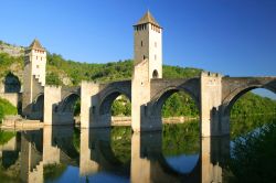 Il pittoresco ponte Valentré sul fiume Lot a Cahors, Francia, in estate. Chiamato anche ponte del Diavolo, venne costruito nel XIV° secolo per collegare le due sponde del fiume Lot ...