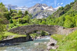 Il ponte in pietra Nadau sul fiume Gave di Gavarnie, Pirenei, Francia.
