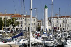 Il porto della città di La Rochelle, Francia. Sullo sfondo, dietro le barche ormeggiate, il faro bianco e verde.



