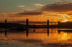 Il tramonto e il ponte Britannia visti da una chiesa dell'isola a Anglesey, Galles, UK.

