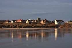 Il villaggio di Bamburgh fotografato dalla spiaggia sul mare del nord, Inghilterra