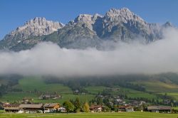 Il villaggio turistico di Leogang fotografato sotto le nuvole, Austria. Sopra, i picchi delle Loferer mountains.
