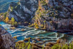 Increspature al calar del sole sulle acque delle cascate Roski Slap, Krka, Croazia. Il canyon in questa parte del fiume si allarga e prende la forma di un imbuto.


