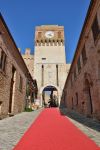 L'ingresso al castello di Gradara, Italia. Uno stretto veicolo acciottolato accompagna alla porta d'ingresso della fortezza medievale protetta da due cinte murarie, la più esterna ...