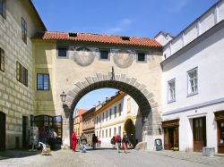 Il sole risplende sulla porta medievale che conduce al castello di Cesky Krumlov, Repubblica Ceca - questa porta di antichissima costruzione rappresenta la via d'ingresso verso il magnifico ...