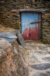 Ingresso di un vecchio edificio a Piodao, Portogallo - Una stradina lastricata porta a questa abitazione in pietra a cui si accede tramite una porta in legno azzurra © Carlos Caetano / ...