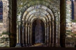 L'ingresso di una chiesa a Dunfermline, Scozia, UK. Il portone in legno impreziosito da belle lavorazioni in ferro è sormontato da 5 arcate in pietra che poggiano su colonne con capitelli.
 ...