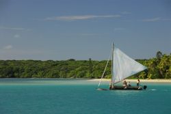 Isola dei Pini, Nuova Caledonia: una piroga nell'Oceano Pacifico. Sullo sfondo, la vegetazione lussureggiante di questo lembo di arcipelago.
