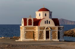 Isola di Creta, prefettura di Lassithi: una chiesa in pietra affacciata sul mare al tramonto.

