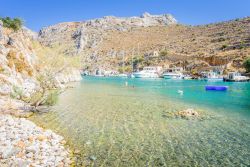 Isola di Kalymnos, Dodecaneso (Grecia): una bella veduta della costa con l'acqua trasparente e le barche da pesca ormeggiate. Sullo sfondo, le colline brulle e aspre di questa terra - © ...