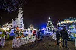 Lituania: le bancarelle del Villaggio di Natale nella Piazza del Municipio di Kaunas "abbracciano" l’albero che svetta durante le feste natalizie.
