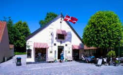 La bandiera danese sventola sulla facciata di un negozio di souvenir a Odense. Siamo nella via che ospita anche il museo Andersen - © Paolo Bona / Shutterstock.com