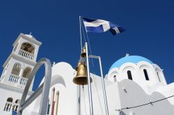 La bandiera greca sventola di fronte a una chiesa dell'isola di Angistri, Grecia - © Dimitris Mitropoulos / Shutterstock.com