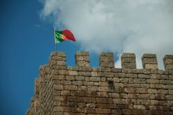 La bandiera portoghese sventola sulla torre del castello di Linhares da Beira. Il villaggio, situato sul versante occidentale della Serra da Estrela, ha probabilmente avuto origine da un castro ...