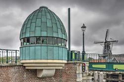 La cabina rotonda sul ponte Catharijne a Haarlem con il tetto e le pareti in rame patinato (Olanda). Sullo sfondo, un mulino a vento - © Frans Blok / Shutterstock.com