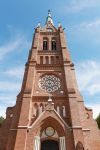 La chiesa dell'Ascensione della Vergine Maria a Palanga, Lituania: sulla sobria facciata in mattoni rossi spicca il rosone decorato.

