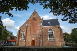 La chiesa Jacobijner nel centro storico di Leeuwarden, Paesi Bassi. La facciata in mattoni rossi è impreziosita da due grandi finestre e da un piccolo rosone.
