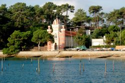La chiesetta di Santa Maria del Capo nel bacino di Arcachon, Francia. La facciata si presenta a strisce alternate bianche e rosse.



