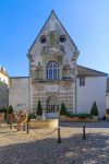 La chiesetta di Santo Stefano in piazza Ziem a Beaune, Francia, con boy scouts che vendono calendari - © RnDmS / Shutterstock.com