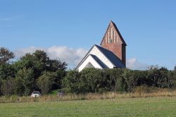 La chiesetta di St. Severin sull'isola di Sylt, Germania, immersa nella vegetazione.
