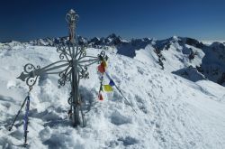 La cima innevata del monte Corno Stella con la croce in ferro, Alpi Orobie (Bergamo).

