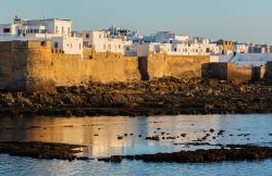 La città bianca di Asilah, Marocco. Una bella veduta dal mare di questa cittadina fortificata costruita probabilmente dai fenici come porto commerciale intorno al 1500 a.C.


