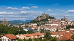 La città di Le Puy-en-Velay (Francia): sullo sfondo la cappella di Saint Michel d'Aiguilhe.
