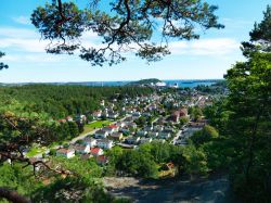 La città norvegese di Kristiansand vista dall'alto delle colline in una giornata di sole. Il mercato del pesce incastonato nel grazioso porticciolo, il centro storico, i musei, i ...