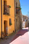 La facciata color ocra di una casa nel centro storico lucano di Guardia Perticara in una giornata di sole.
