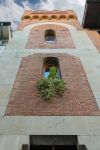 La facciata in pietra e mattoni di un antico edificio di Viareggio, Toscana, con decorazioni floreali al centro.



