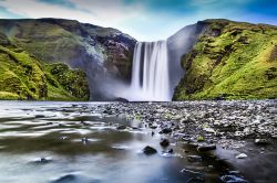 La famosa cascata di Skogafoss, Islanda, fotografata al crepuscolo. Secondo un'antica leggenda un vichingo stabilito nella zona nascose un forziere colmo di monete d'oro nella caverna ...