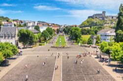 La grande piazza di fronte al santuario di Nostra Signora a Lourdes, Francia, in estate. Dopo Roma, è la prima città di pellegrinaggio d'Europa.

