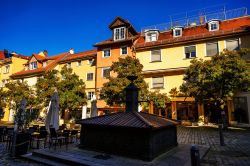 La graziosa Paradise Square a Lindau in autunno con fontana, alberi e vecchi edifici, Germania.

