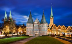 La Holstentor illuminata di notte con decorazioni natalizie, Lubecca, Germania.
