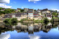La parte storica di Argentat si riflette sulle acque della Dordogne in Aquitania, Francia del sud